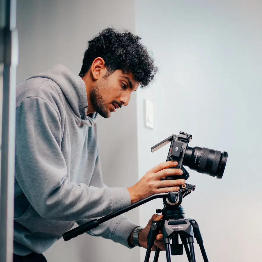 Vidéaste qui ajuste sa caméra sur trépied